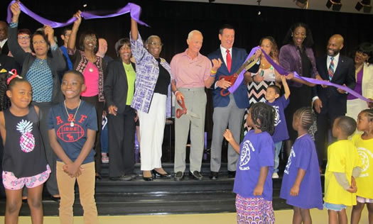 Harris Rosen cutting ribbon for school