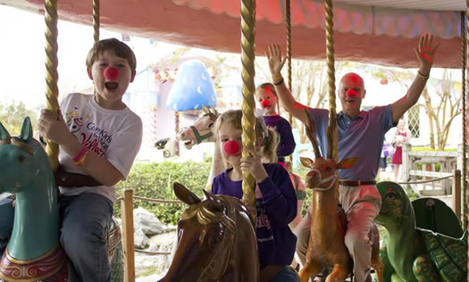 Harris Rosen riding carousel with kids