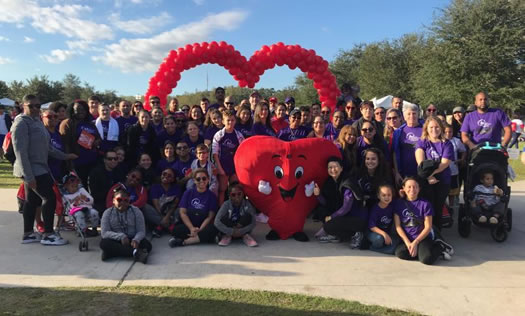 Volunteers taking picture with heart mascot