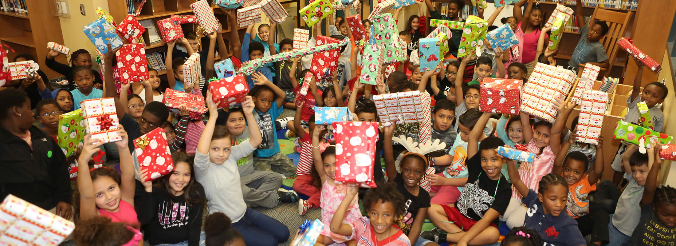 Children holding up Christmas presents, part of the Tangelo Park Program